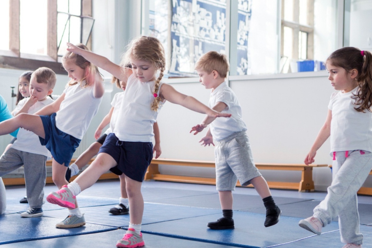 Kinder beim Tanzunterricht in der Turnhalle, konzentriert und aktiv..