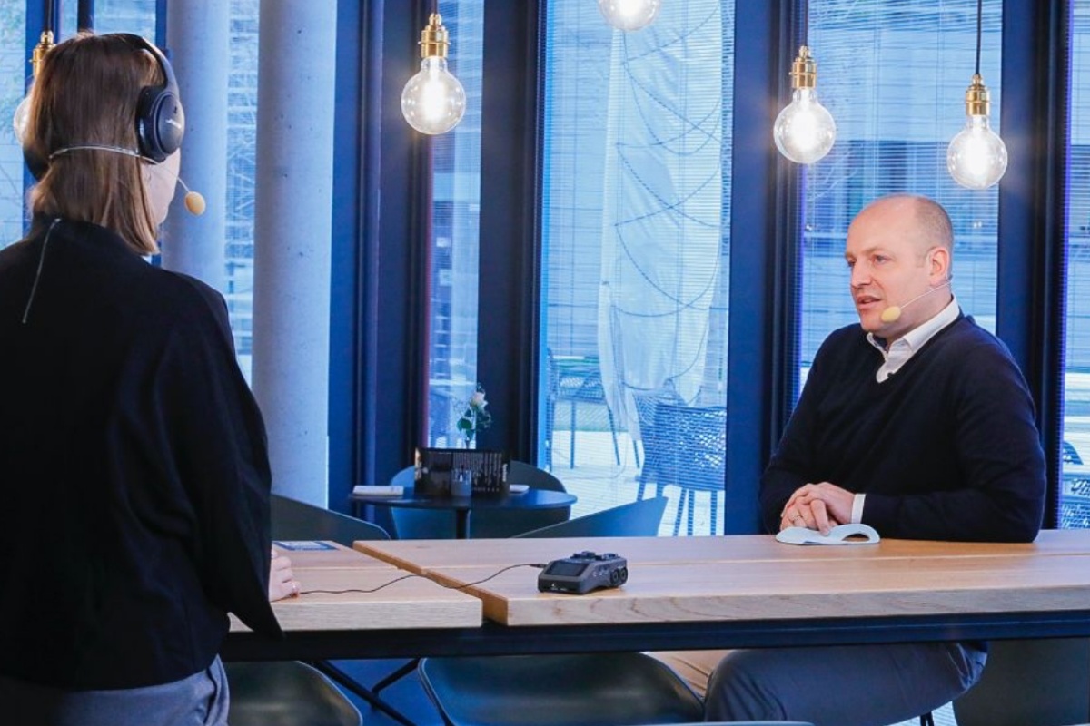 Zwei Personen führen ein Podcast-Interview in modernem Büro.