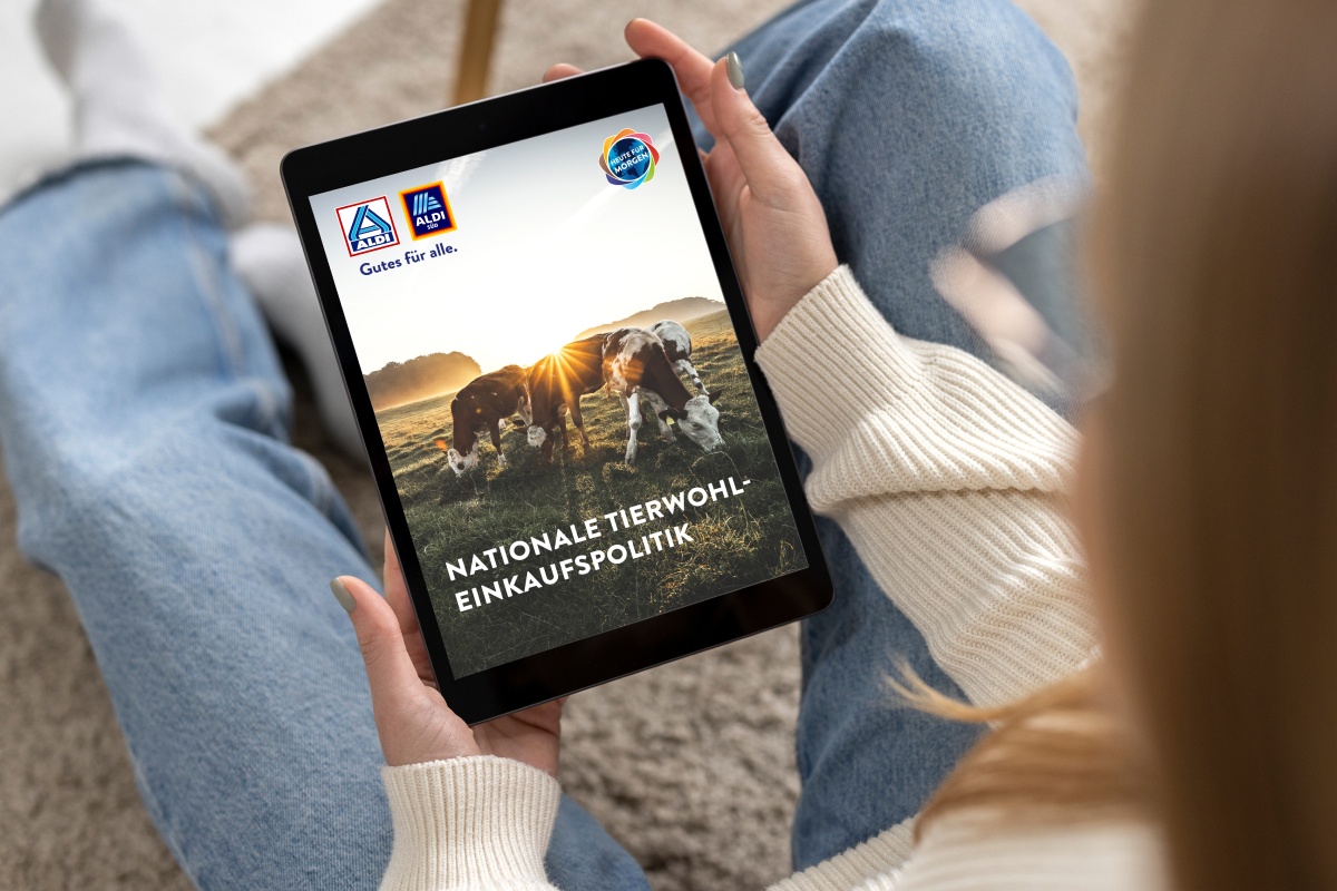 Eine Person ließt den ALDI Leitfaden zur Tierwohl Einkaufspolitik.