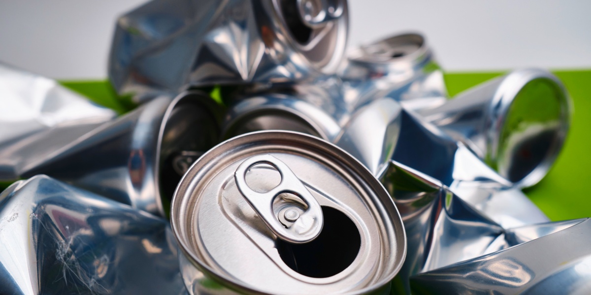 Zerdrückte alte Getränkedosen liegen auf einem Haufen zur Weiterverarbeitung.