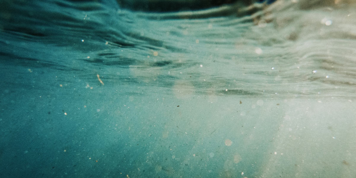 Kleine Plastikpartikel treiben im Ozean umher.