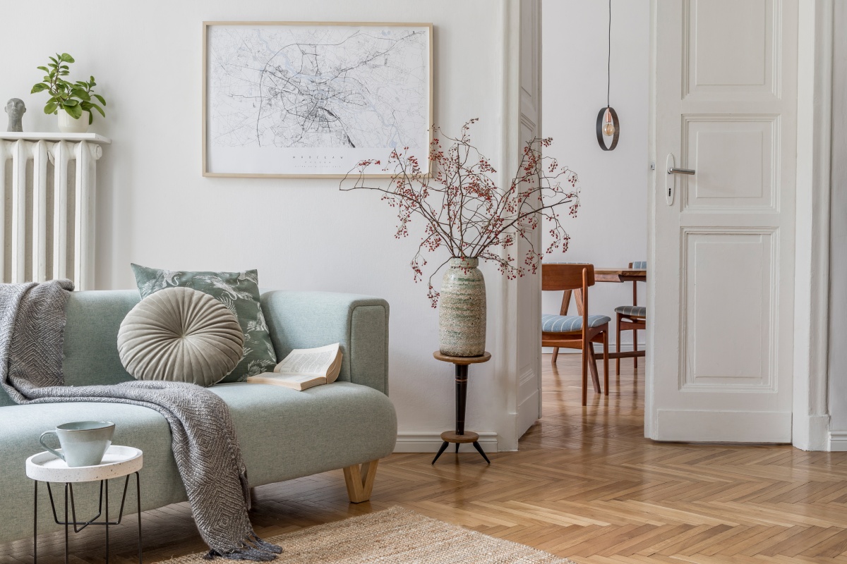 Ein trendiges Sofa steht vor einer Wand in der Trendfarbe greige