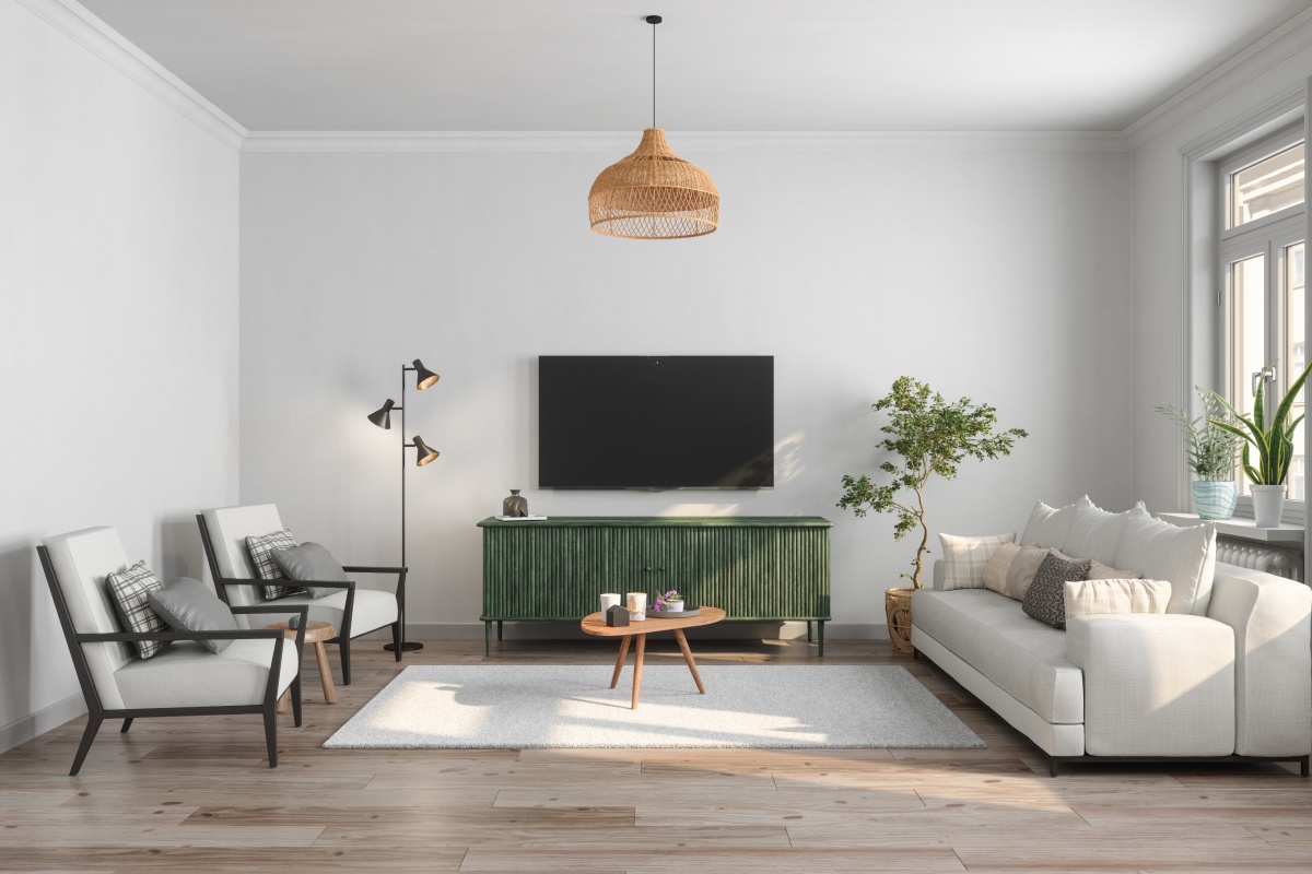 Ein hellgraues Sofa mit kuscheligen Decken und Kissen, an der Wand ein Smartbildschirm.