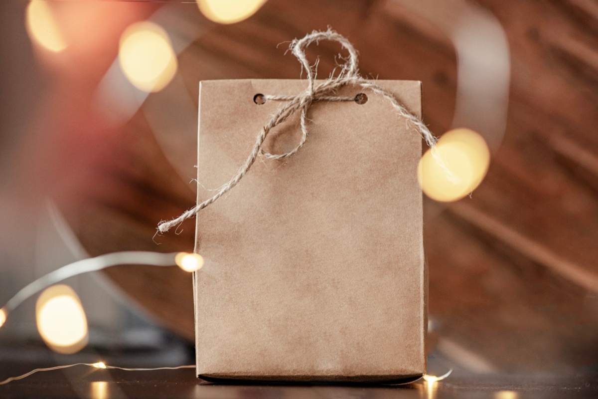 Geschenktüte aus braunem Papier, mit Juteschnur verschlossen.