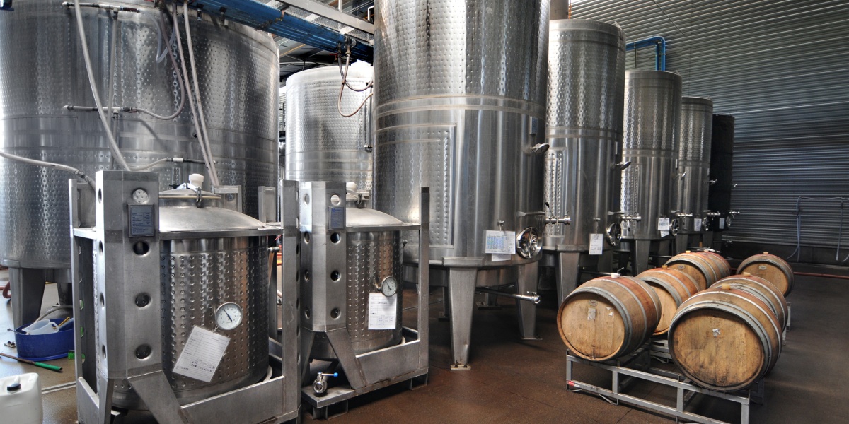 Gärbehälter aus Edelstahl und Holzfässer.