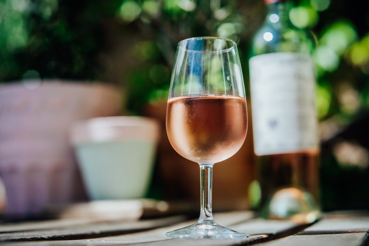 Ein gekühltes Glas Roséwein auf einem Tisch.