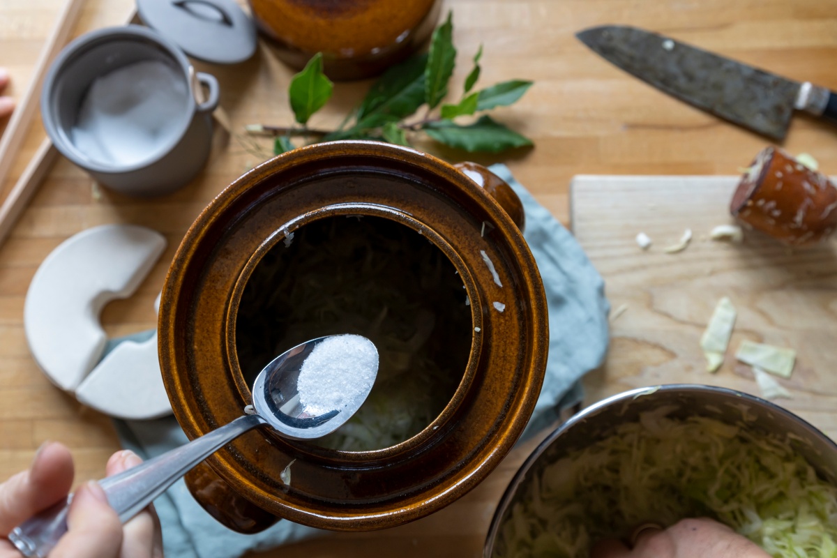 Ein Teelöffel Salz wird in Gurkentopf gegeben.