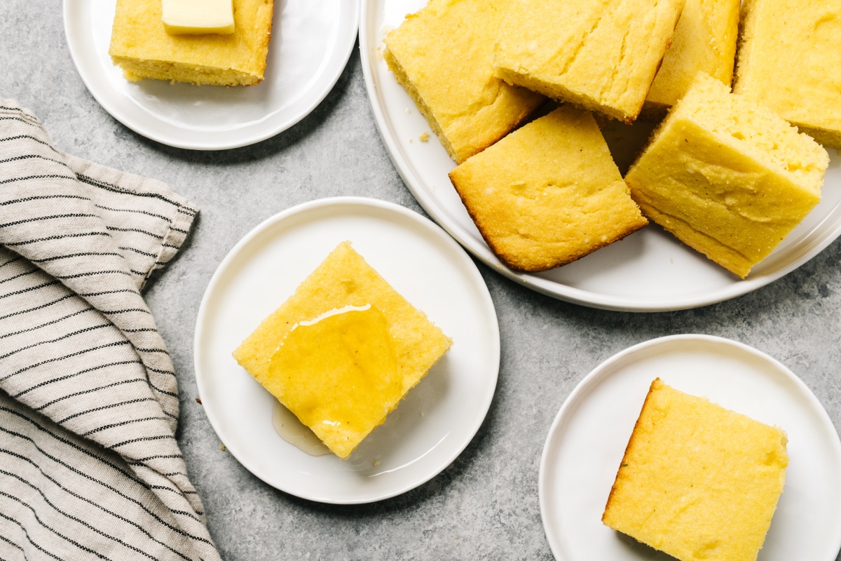 Goldfarbene Polentastücke aus glutenfreiem Maismehl auf Tellern.
