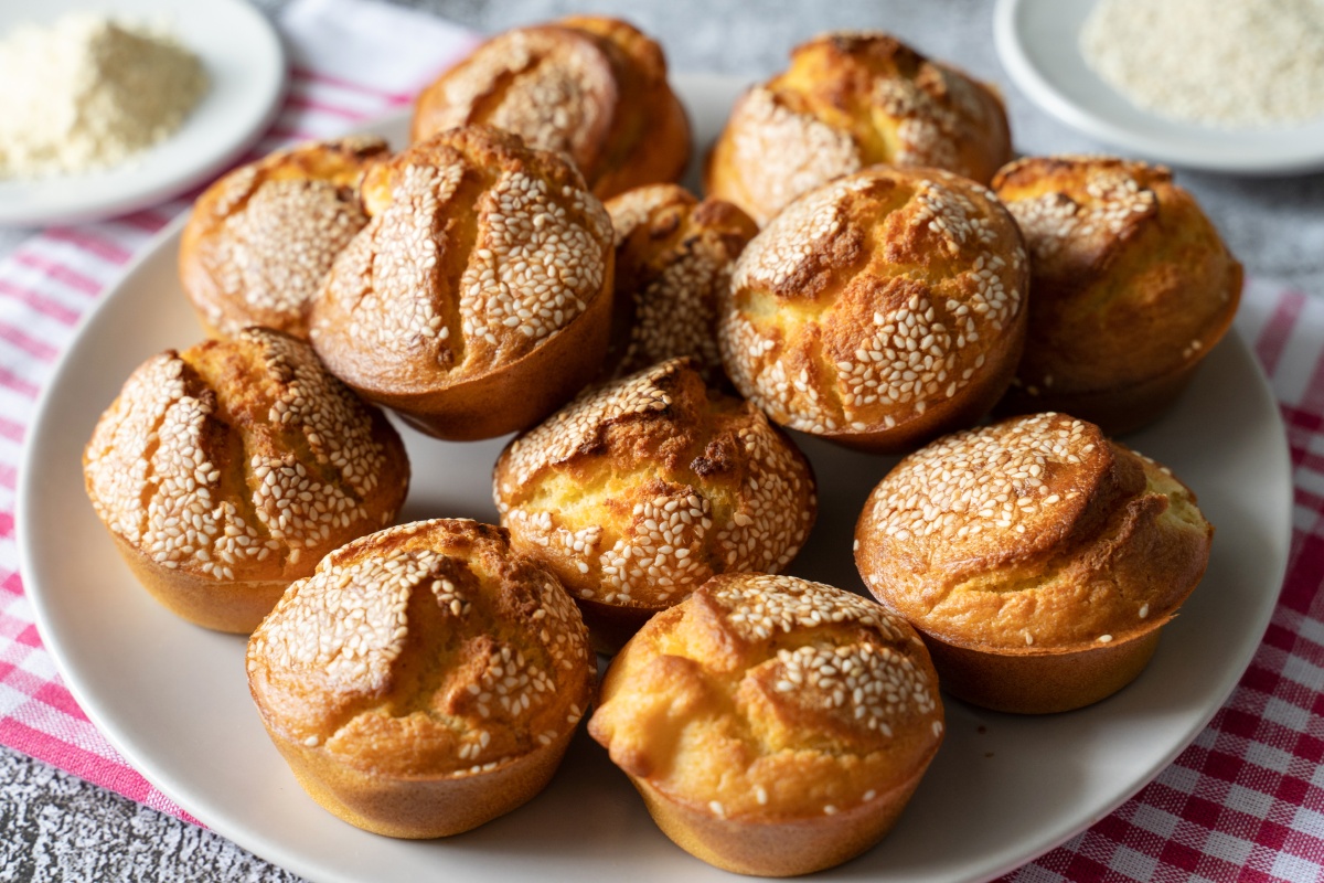 Herzhafte und glutenfreie Muffins mit Sesam-Topping auf einem Teller.