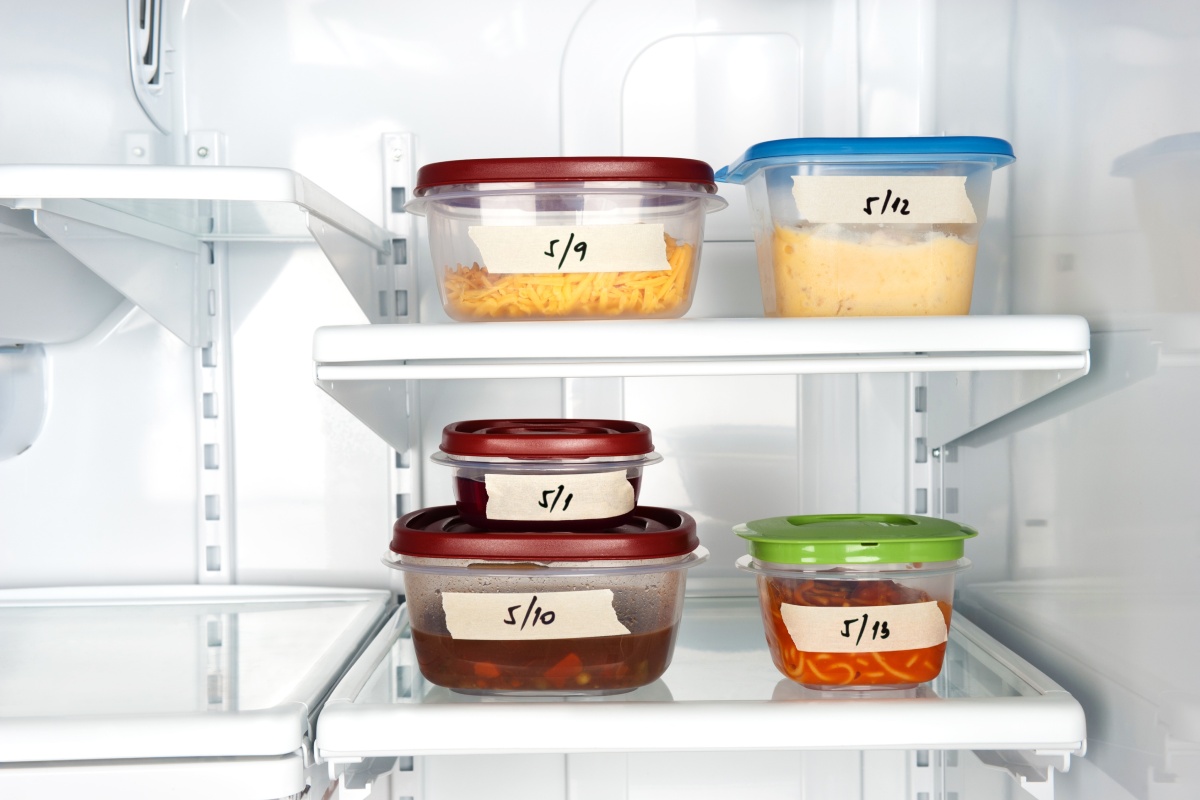 Gefrierfach mit beschrifteten Behältern, die verschiedene gefrorene Lebensmittel enthalten, wie Suppe und Käse.