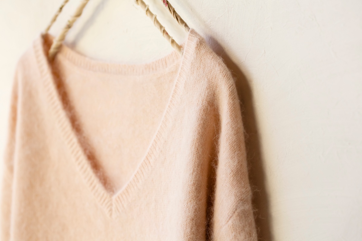 Ein Pullover aus Kaschmir hängt an einem Kleiderbügel.