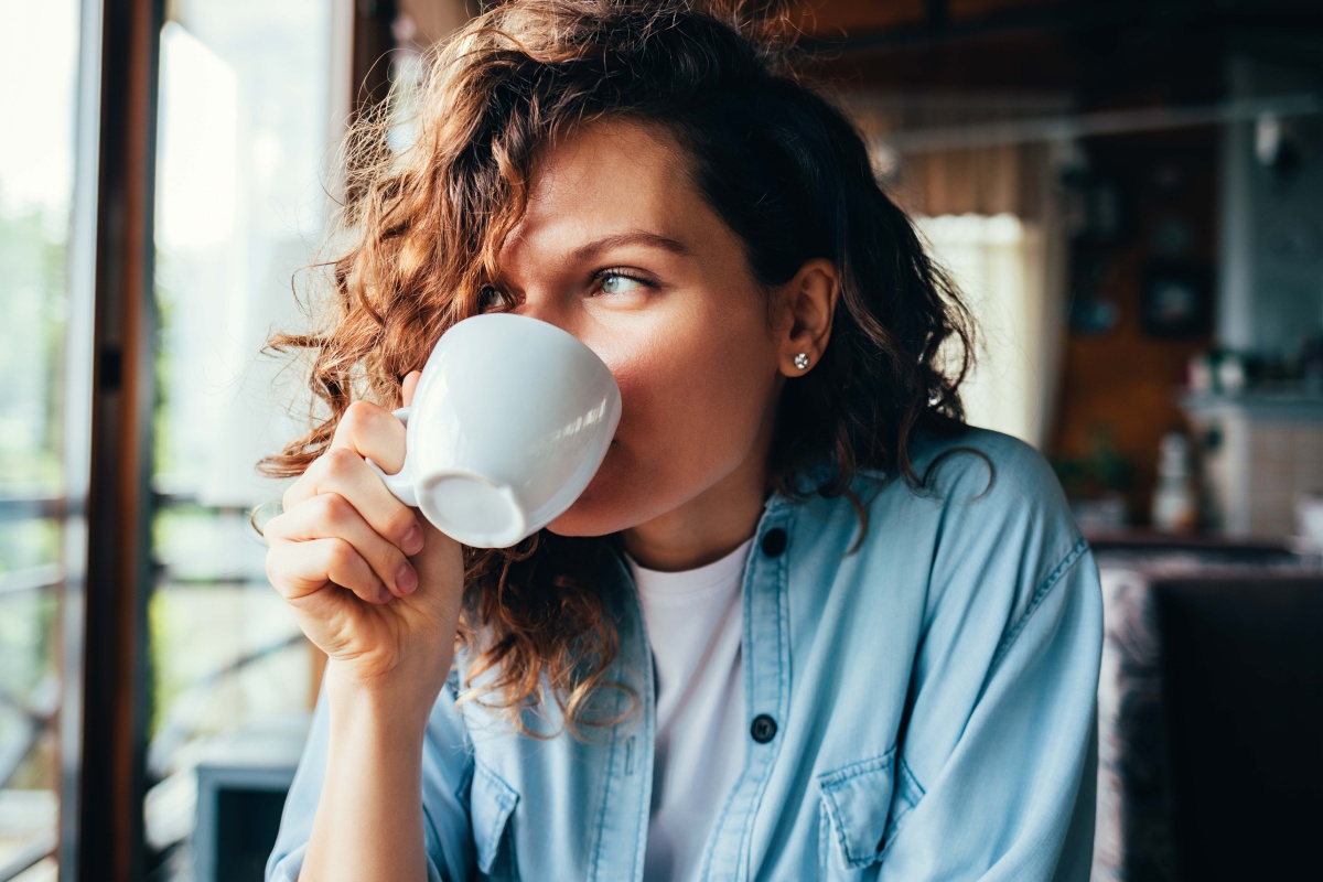Eine junge Frau genießt ihren Morgenkaffee.