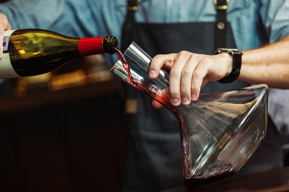 Rotwein wird in eine Dekantierkaraffe gegossen.