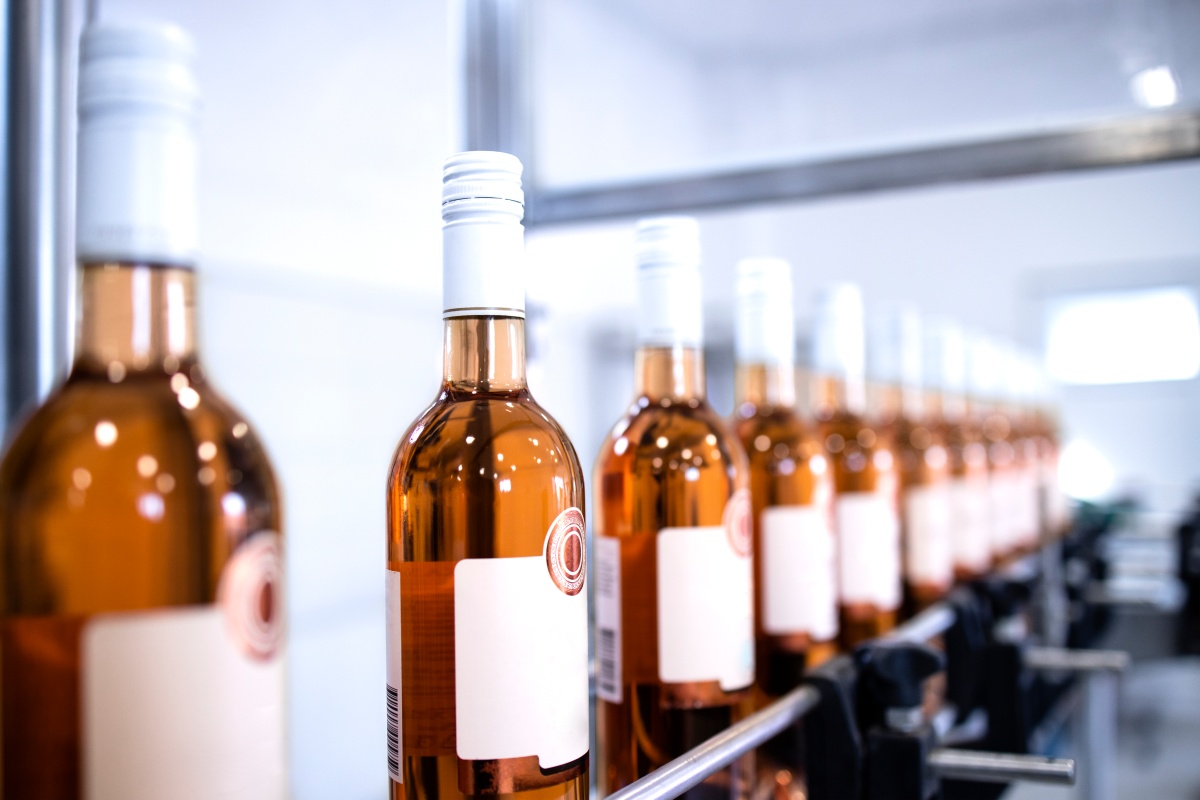 Reihe von Flaschen mit Roséwein in der Fabrik, die nach der Abfüllung bereit stehen.