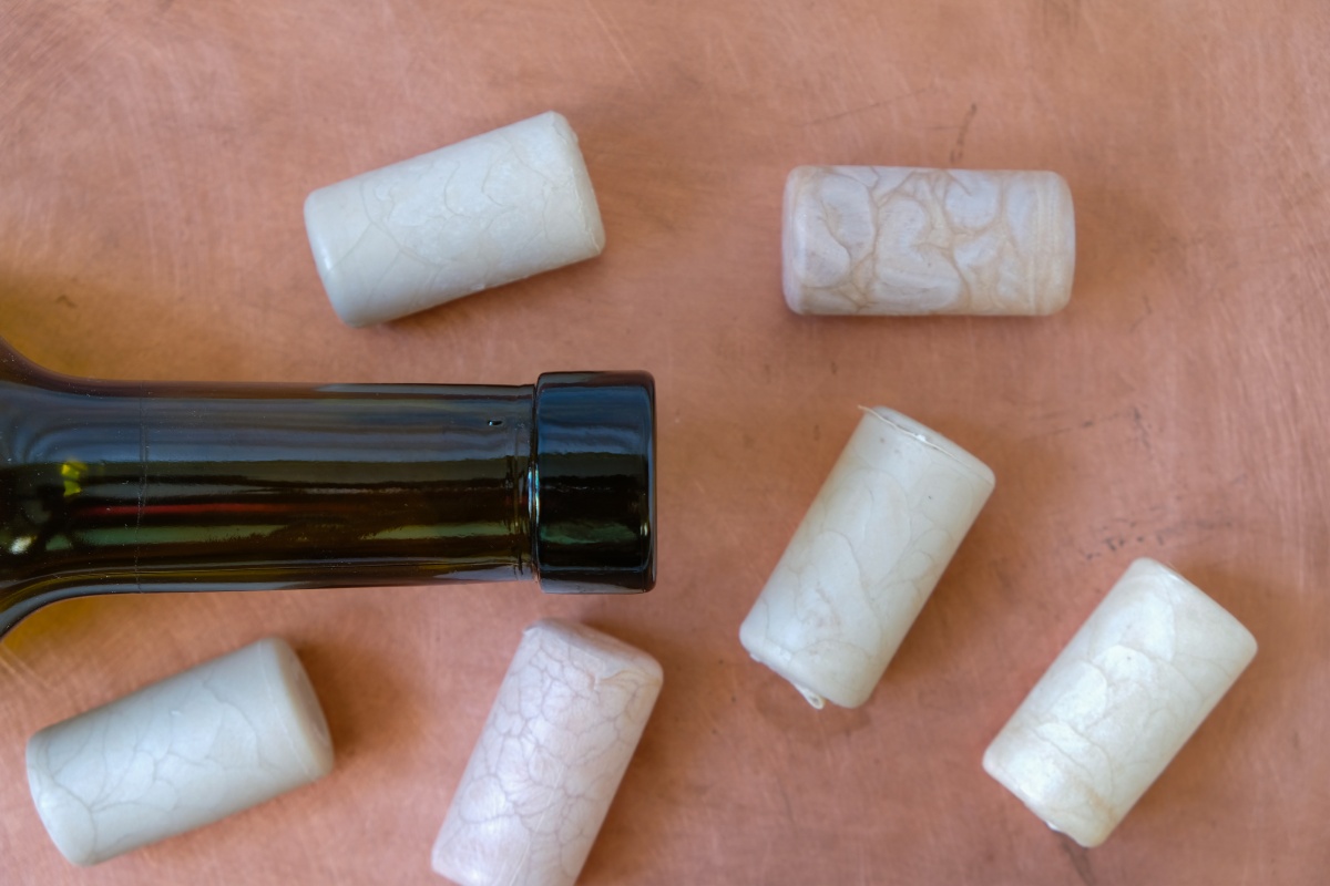 Kunststoffkorken neben einer Flasche Wein.