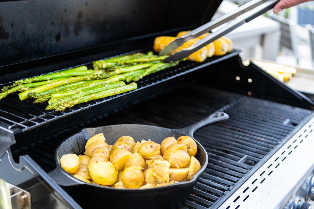 Grüner Spargel, Kartoffeln und Maiskolben auf dem Grill.