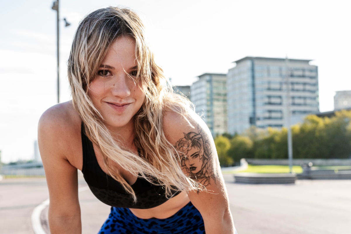 Junge Frau in sommerlichem Sportlook im Skate-Park.