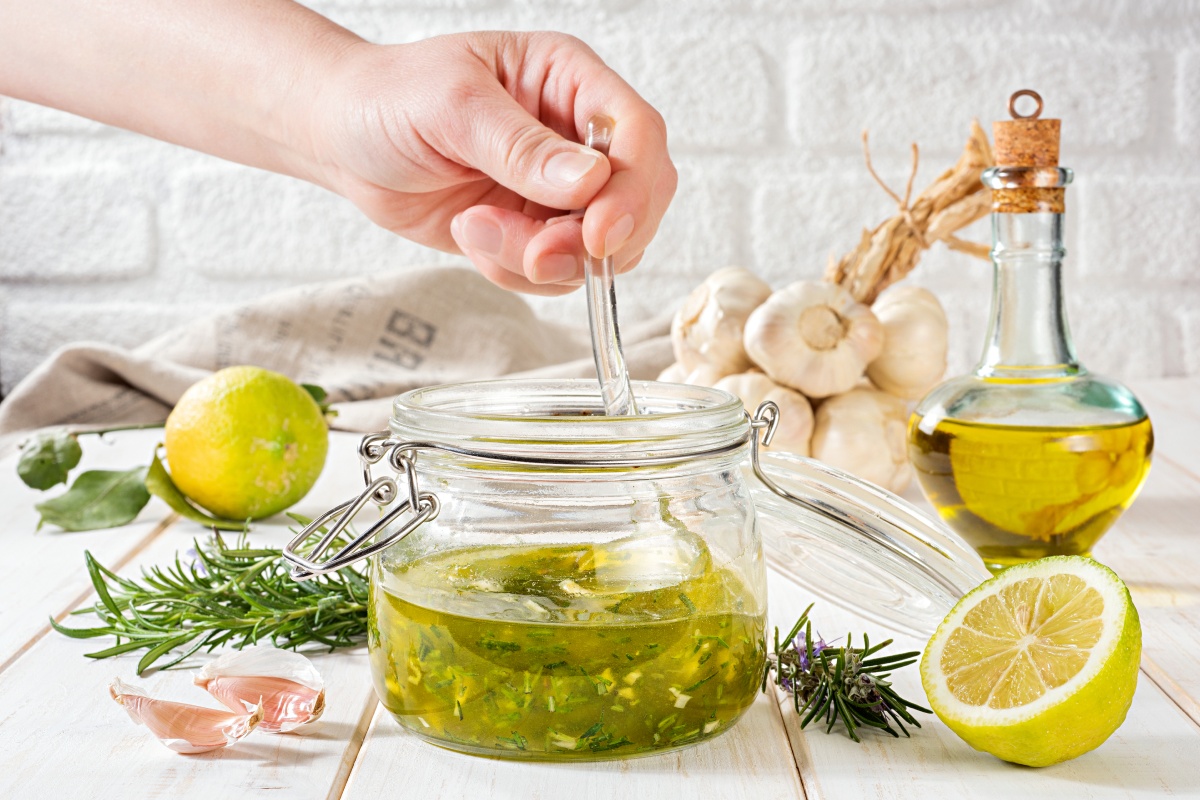 Jemand bereite ein Kräuteröl aus Resten von Kräutern zu.