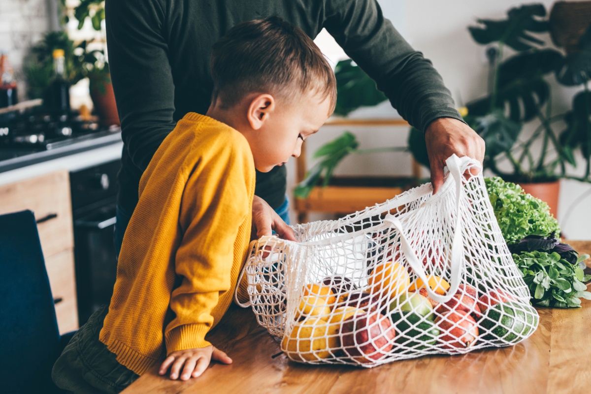 Ein Vater zeigt seinem kleinen Sohn die Lebensmitteleinkäufe.