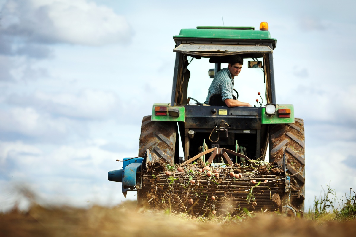 Ein Landwirt sitzt in seinem Tracktor und pflügt ein Feld um.