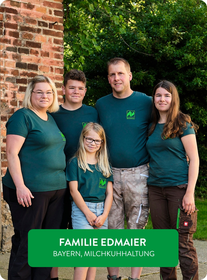 Familie Edmaier steht gemeinsam vor ihrem Biohof.
