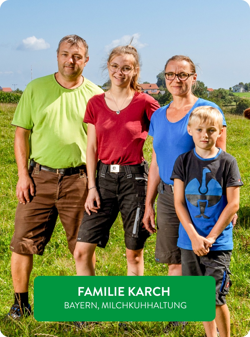 Familie Karch steht gemeinsam auf der Wiese.
