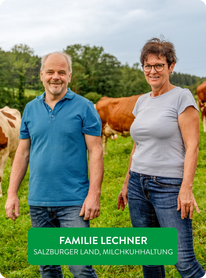 Naturland-Landwirte Herr und Frau Lechern vor ihren Kühen auf einer Wiese.