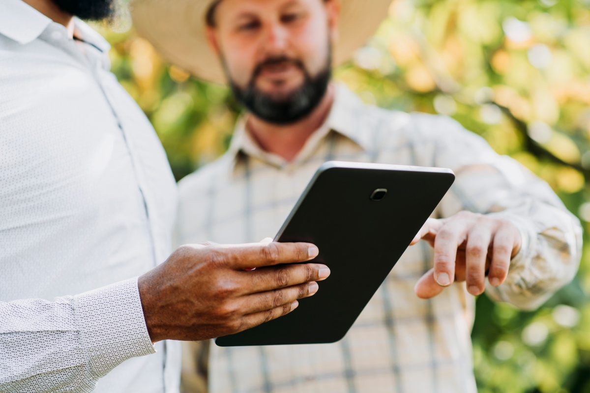 Zwei Personen nutzen Tablet im Freien.