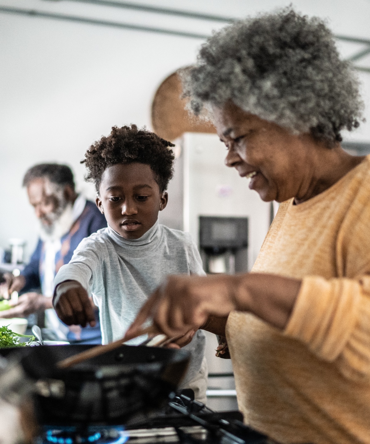 Kind und Großmutter kochen gemeinsam in der Küche.