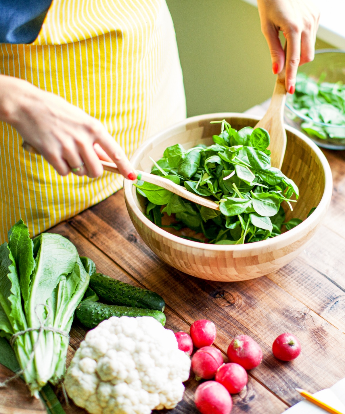 Eine Frau vereitet einen Salat zu.