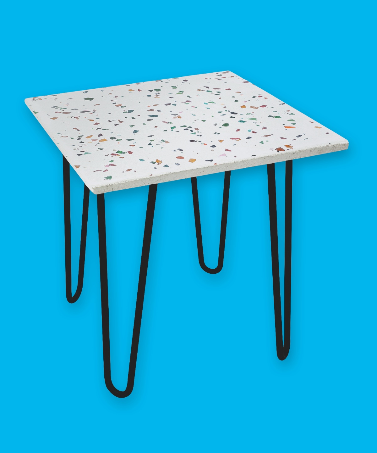 Viereckiger Terrazzo-Tisch mit gebogenen Tischbeinen vor blauem Hintergrund.