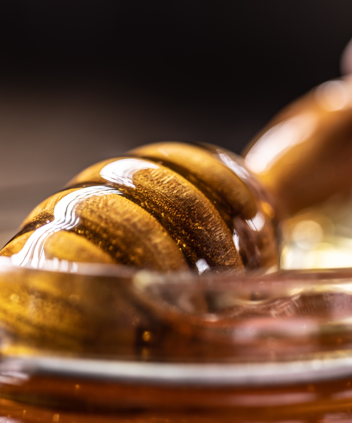 Nahaufnahme eines Honiglöffels mit frischem, goldfarbenem Honig.