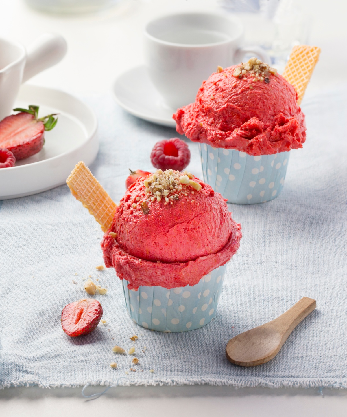 Zwei Erdbeersorbets angerichtet wie Cupcakes auf einem gedeckten Tisch.