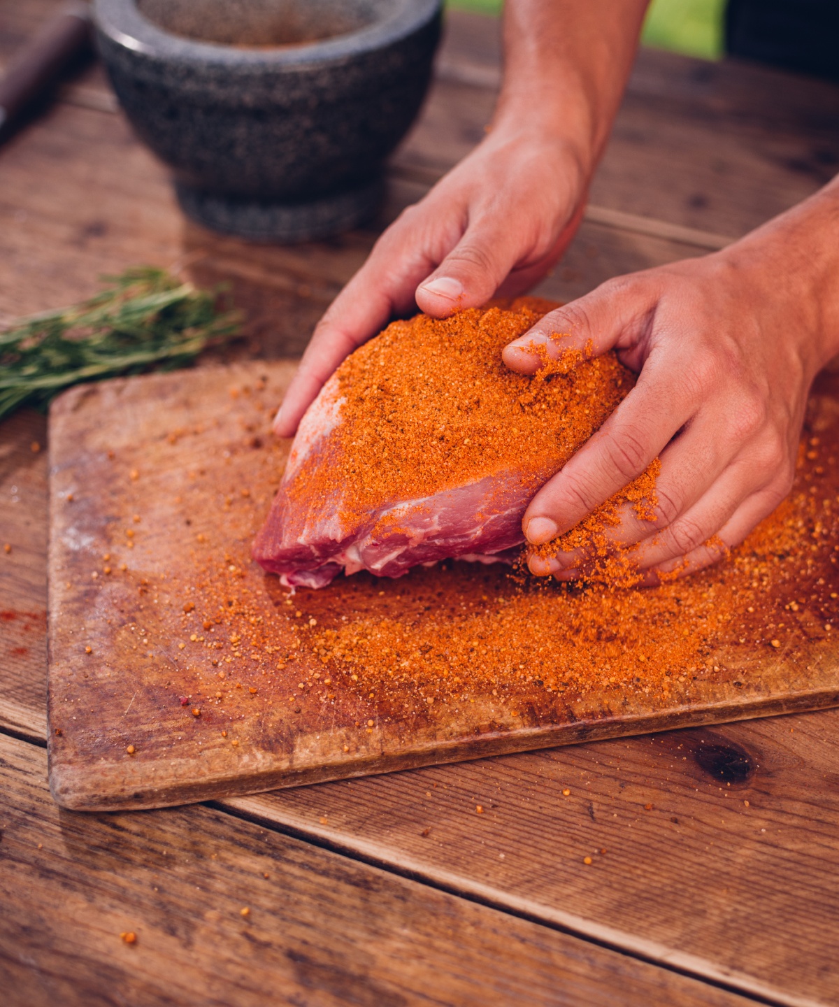 Eine Person reibt ein Stück Fleisch mit der Trockenmarinade Rub Magic Dust ein.