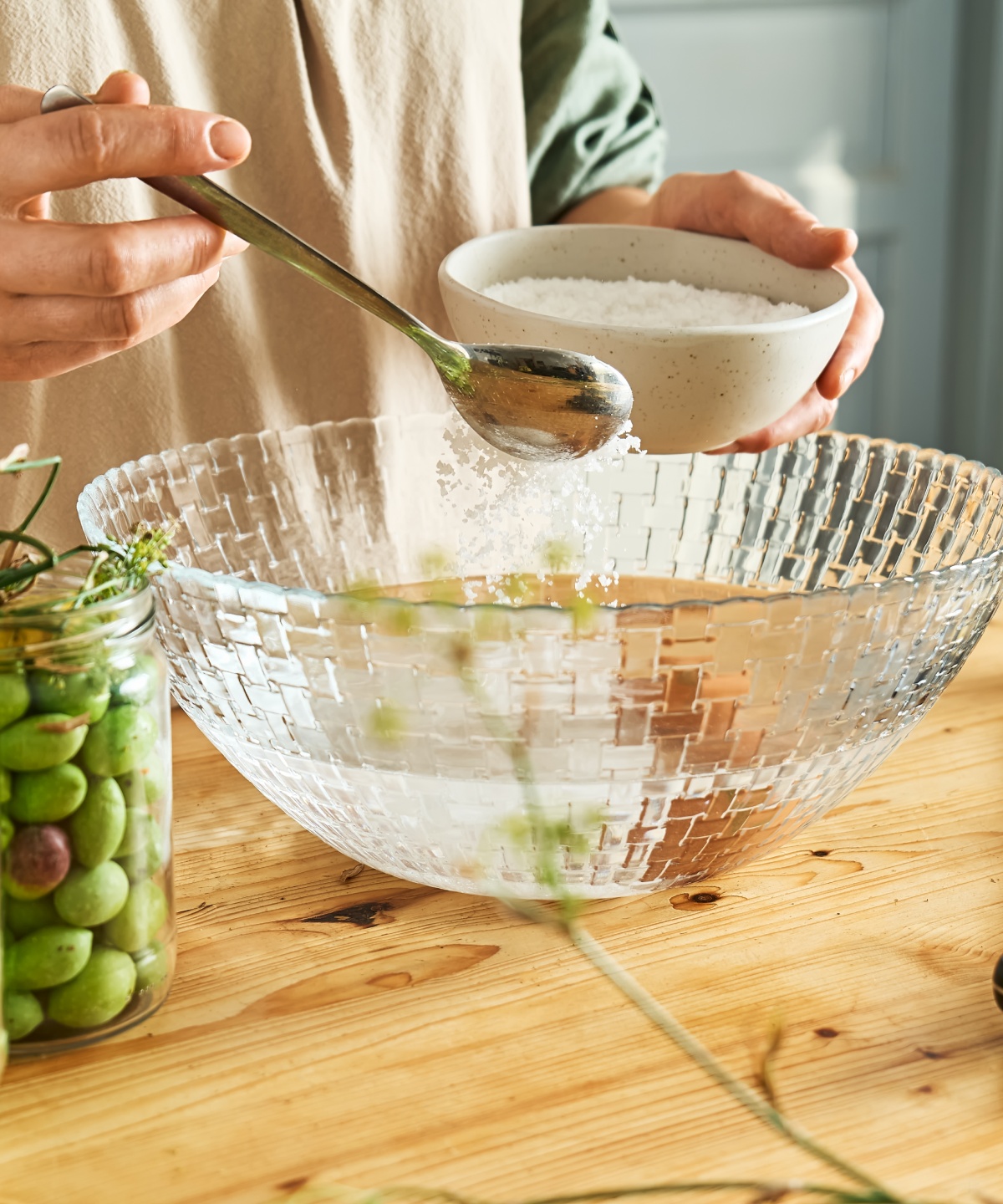 Salz rieselt in eine Schüssel mit Wasser.