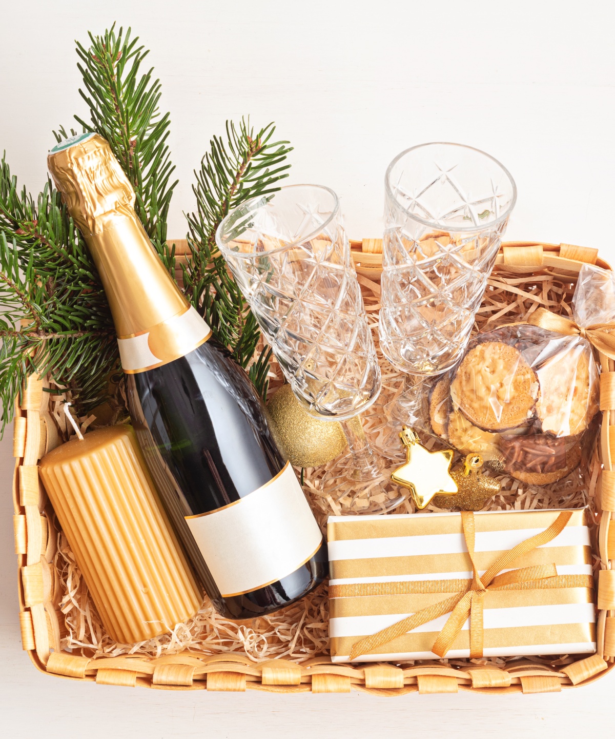 Geschenkkorb im Gold-Look mit Sekt, Gläsern- Leckereien und Dekoration.