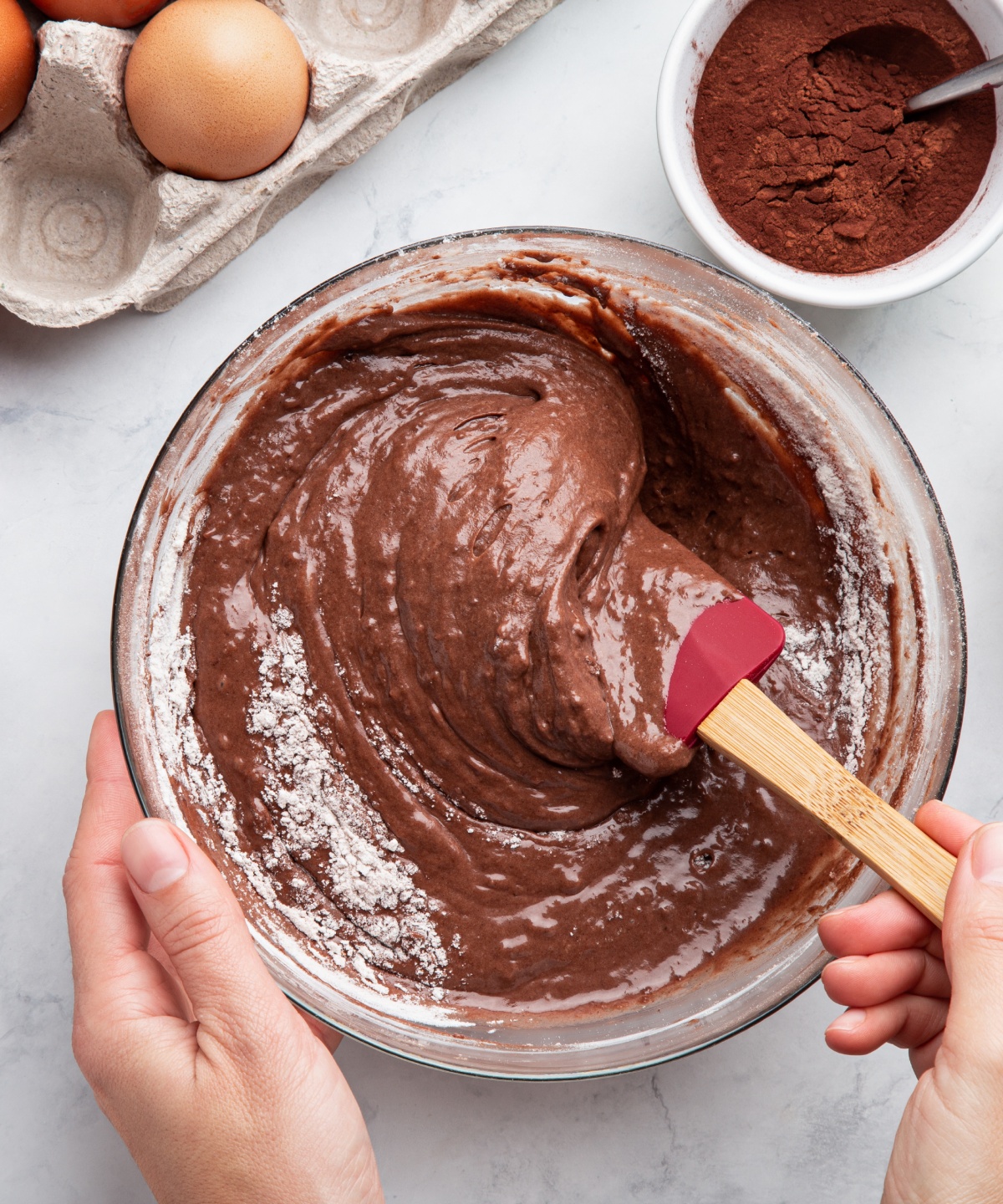 Eine Person rührt einen glutenfreien Schokoladenteig in einer Schüssel an.