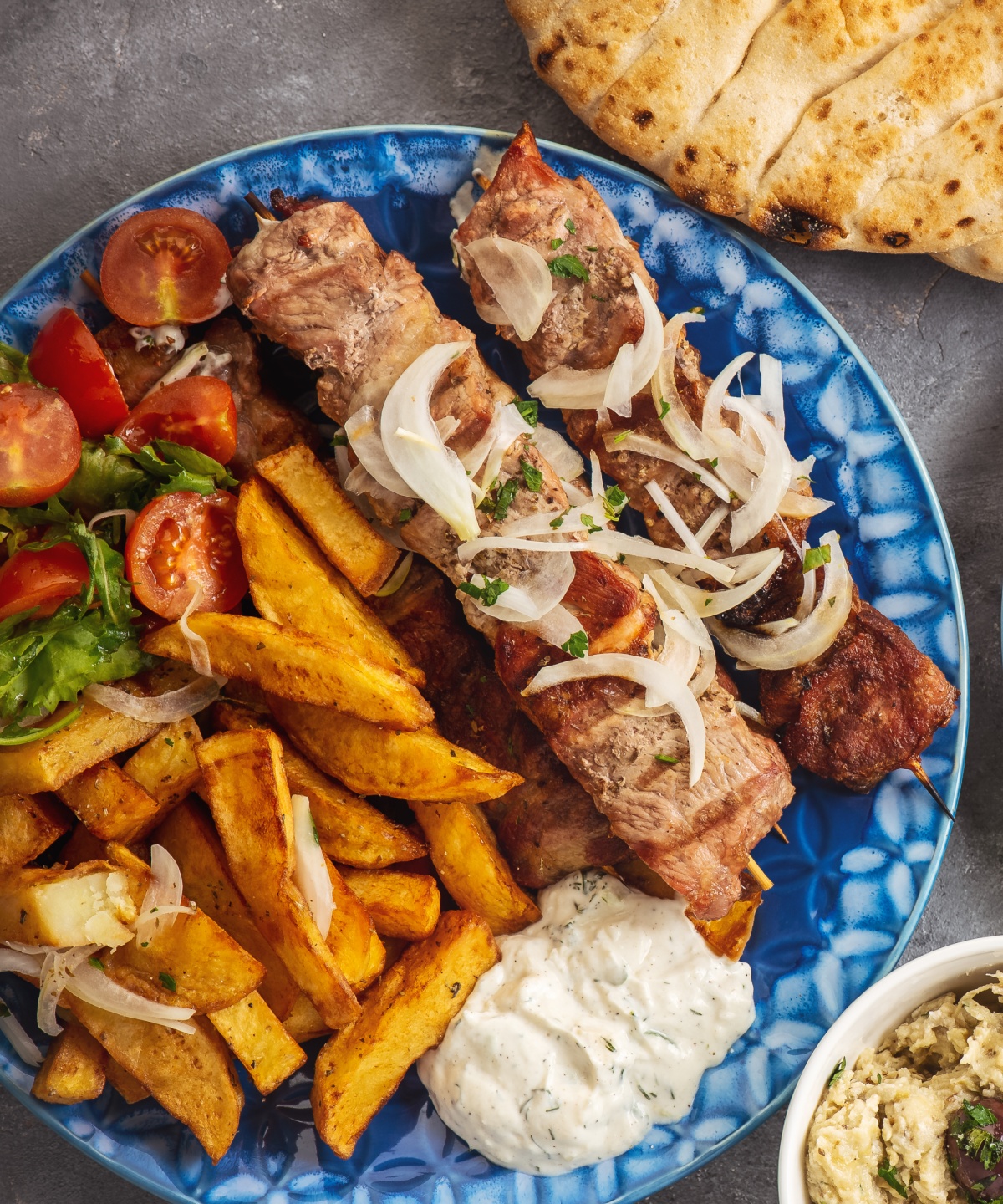 Ein typisch griechischer Grillteller mit Lammspieß, Kartoffel und Tzatziki