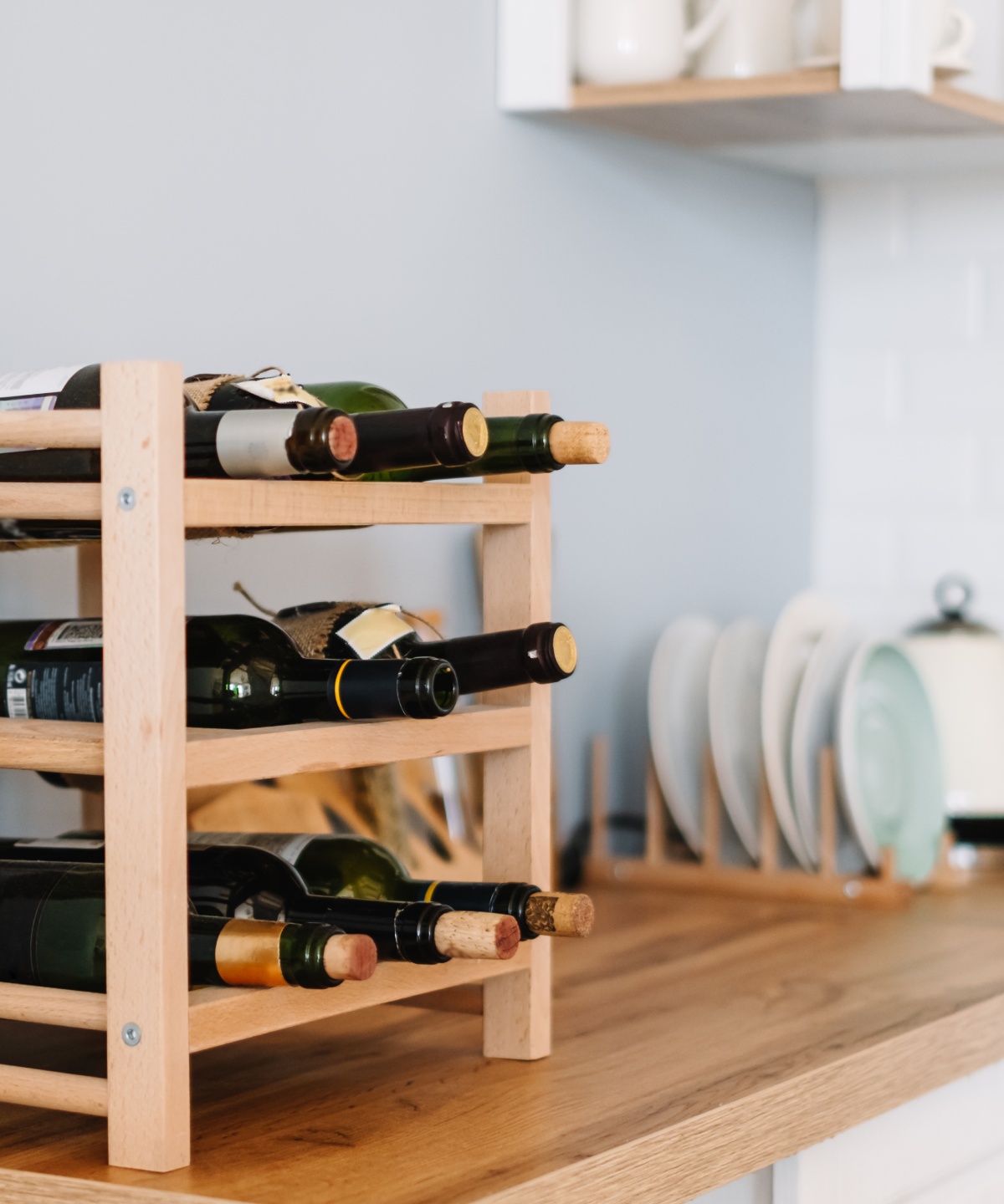 Ein kleines hölzernes Weinregal auf einer Küchenzeile.