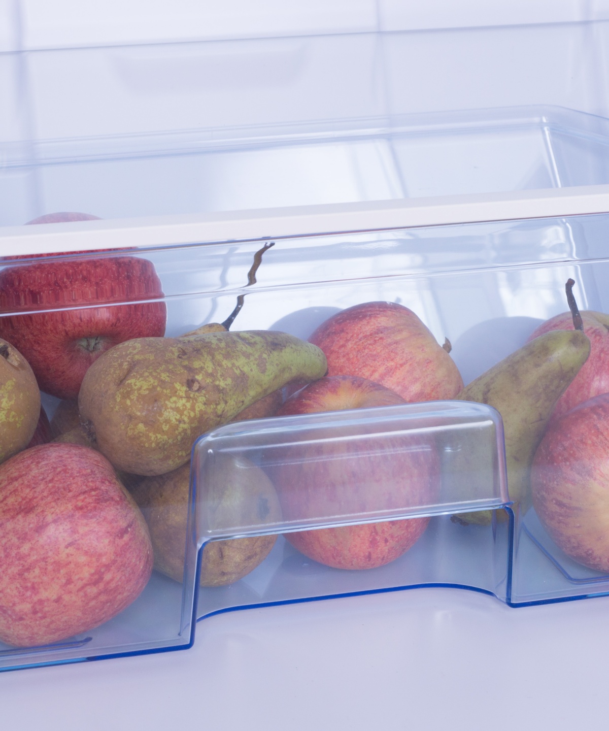 Kühlschrank-Schublade mit frischen Äpfeln und Birnen.