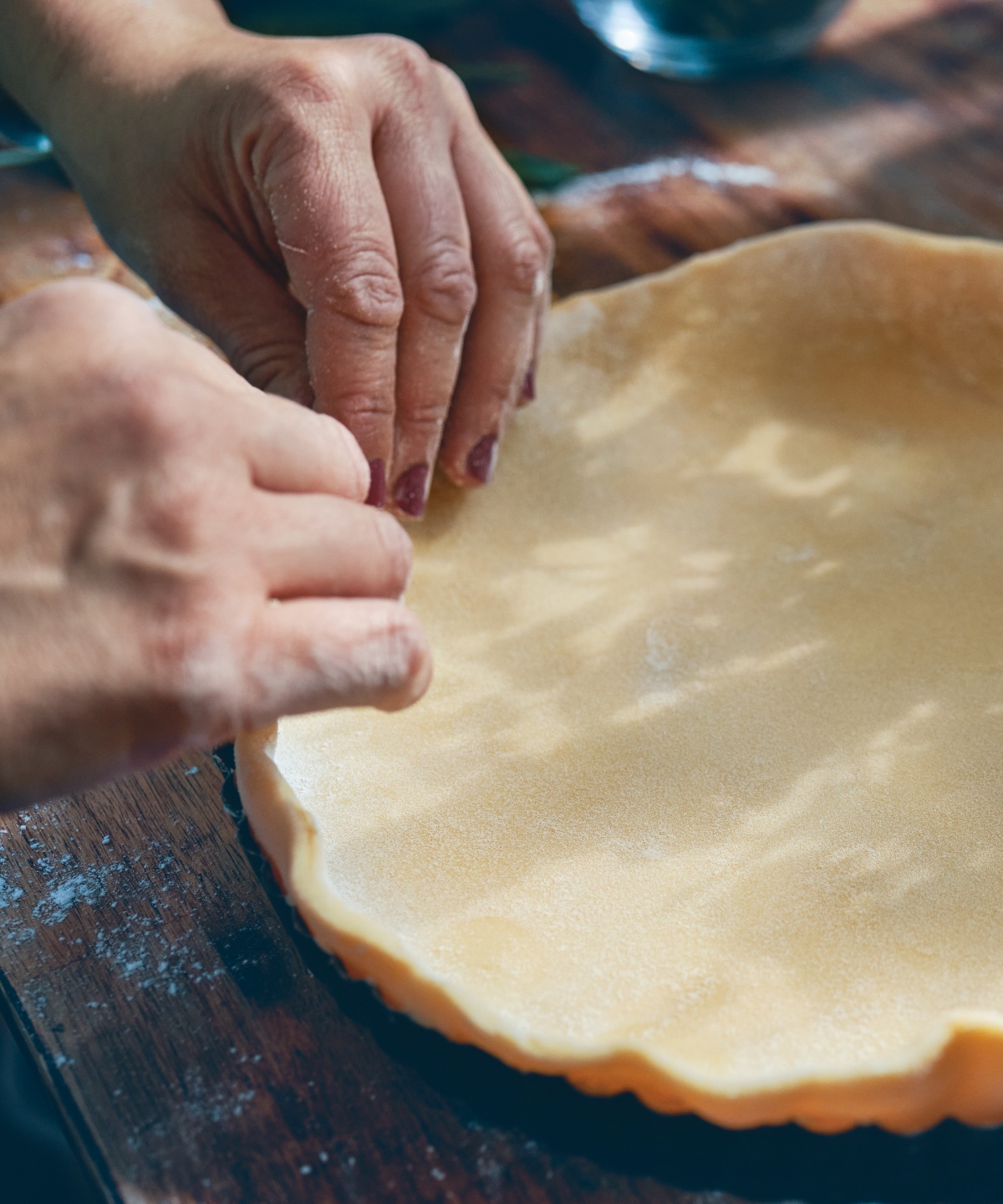 Der Teig für den Quiche-Boden wird in die Form gedrückt