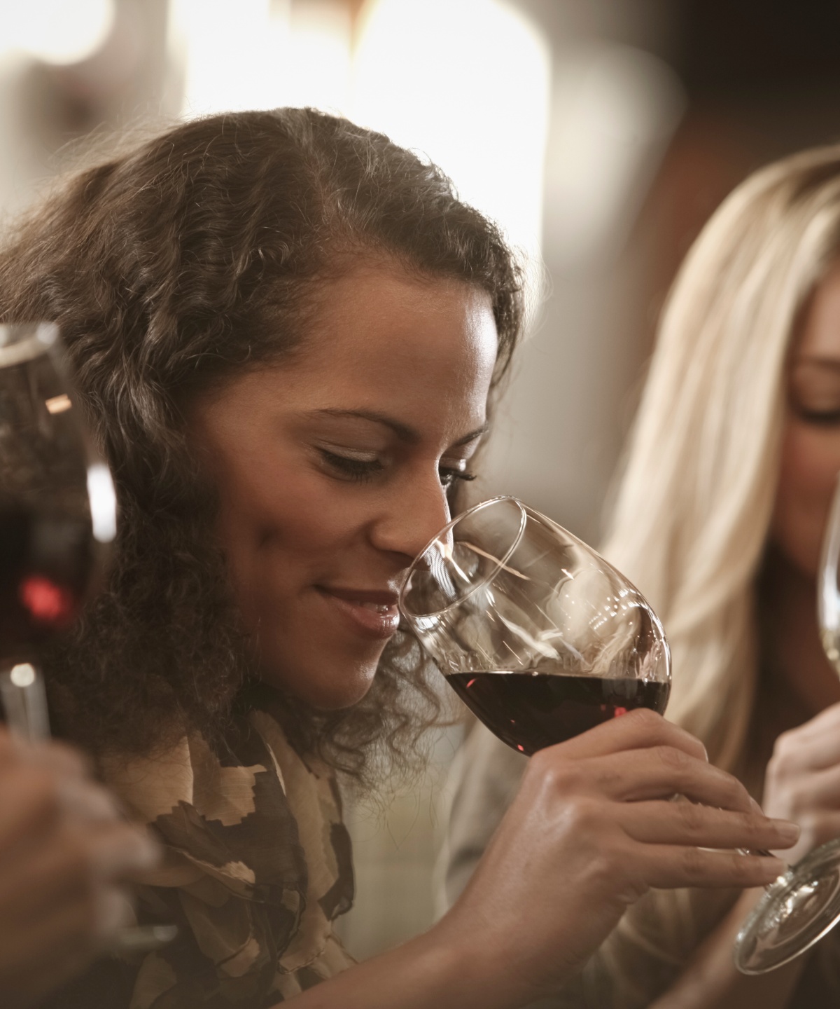 Frauen bei einer Weinprobe, eine trinkt Rotwein, die andere Weißwein.
