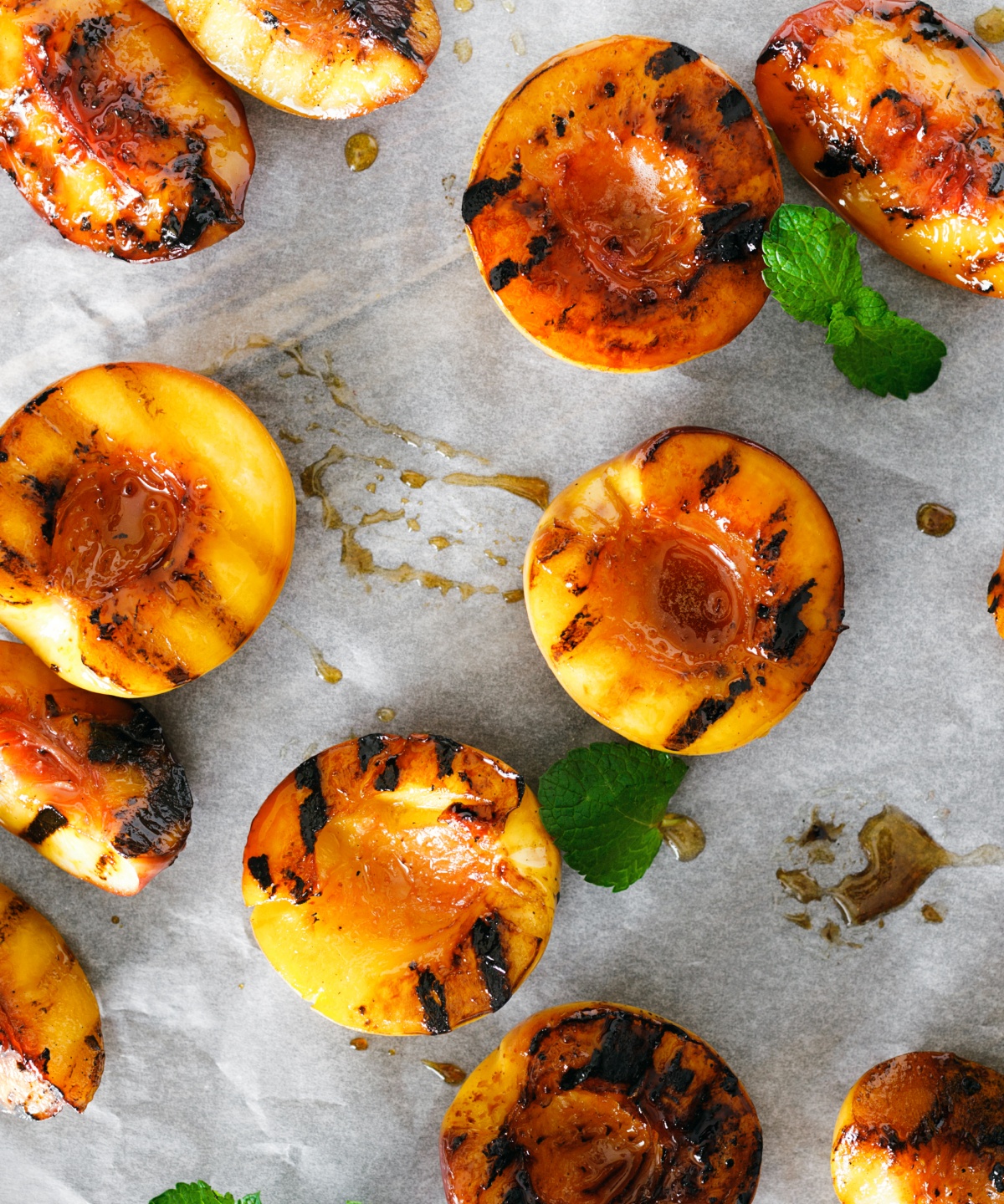 Geröstete Pfirsiche liegen auf Backpapier.