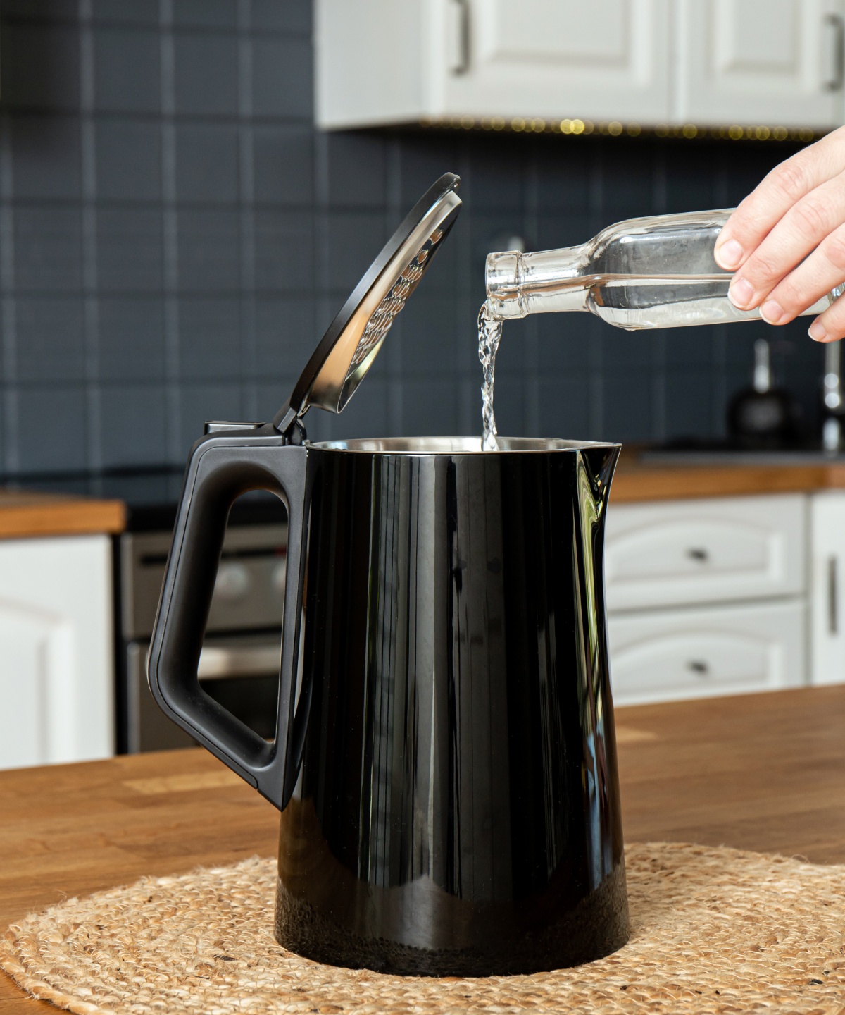 Eine Person füllt Essig in einen Wasserkocher.