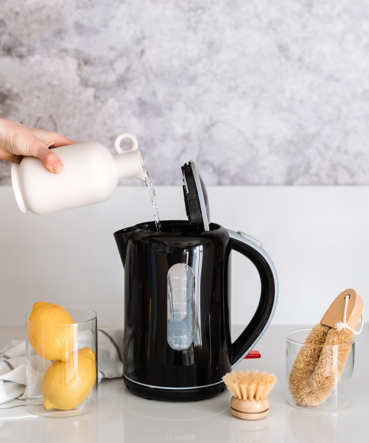 Ein Person füllt Zitronensaft in einen Wasserkocher