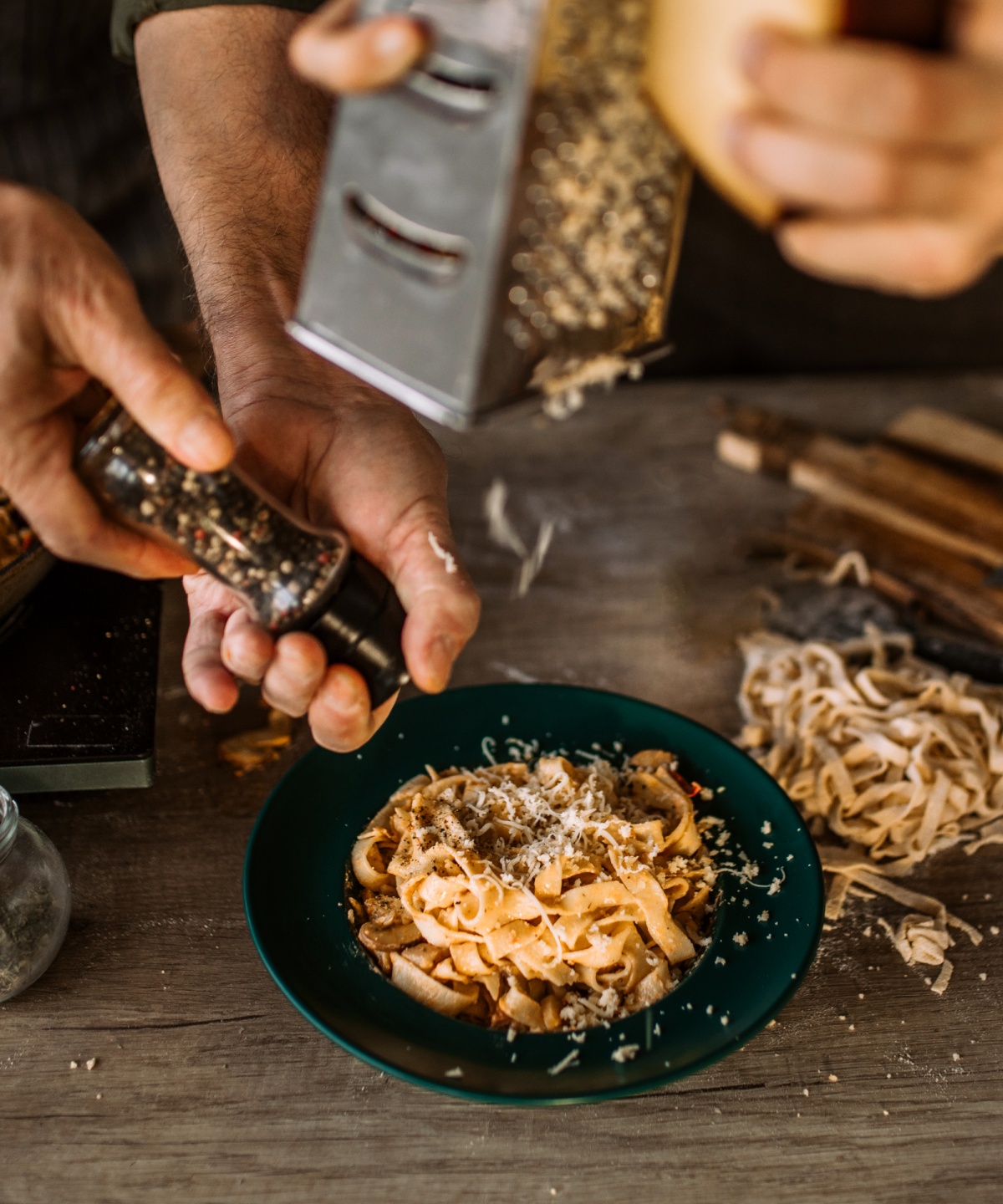 Zwei Personen bereiten zusammen ein schlichtes Pasta Gericht mit ausgewogenen Zutaten zu.