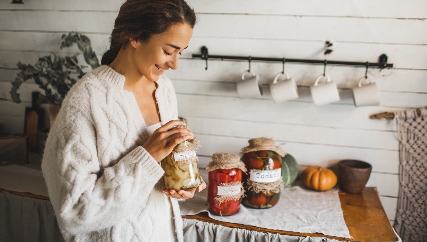 Frau mit Einmachgläsern mit fermentiertem Gemüse.