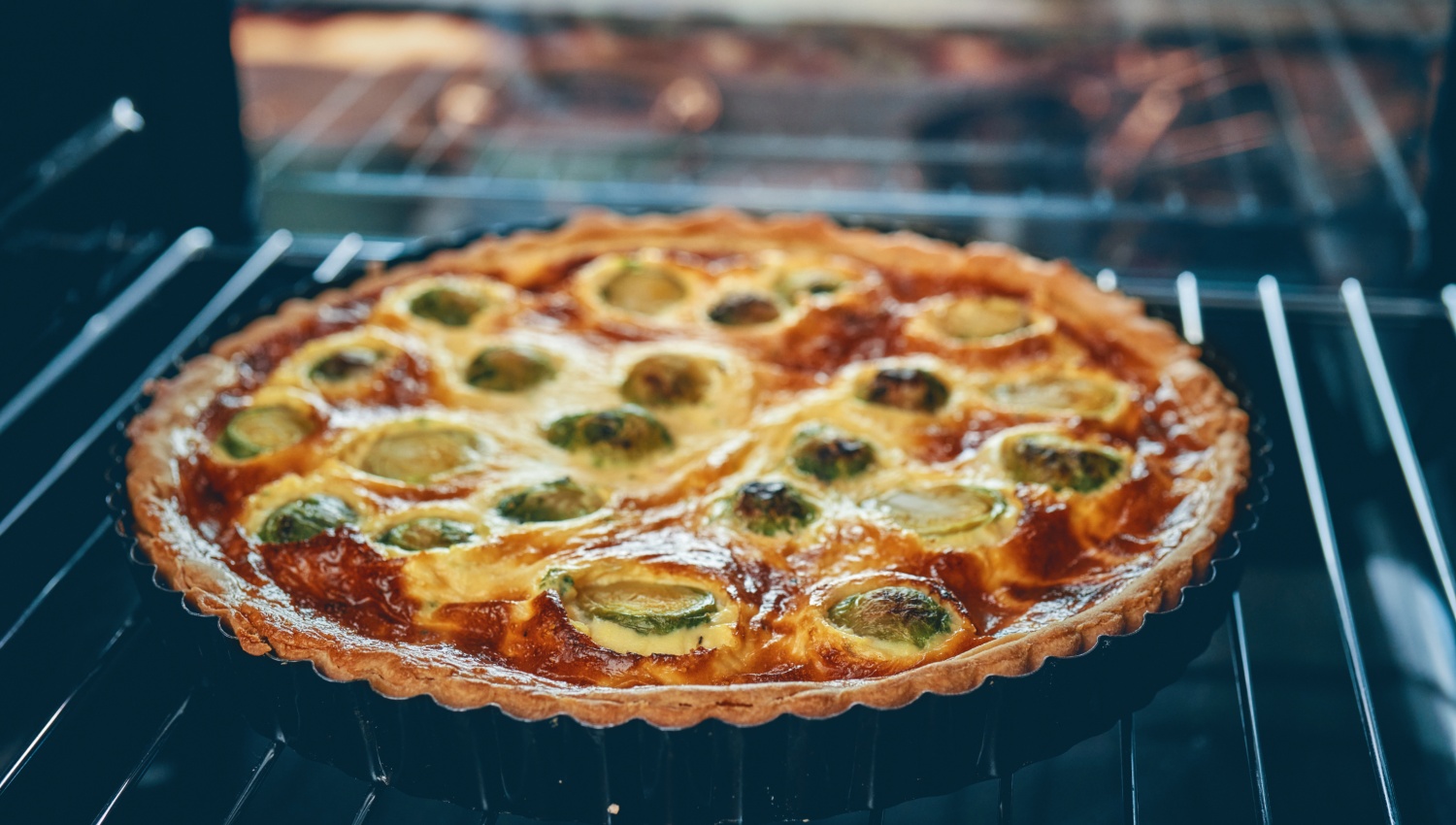Quiche goldbraun gebacken auf einem Ofenrost