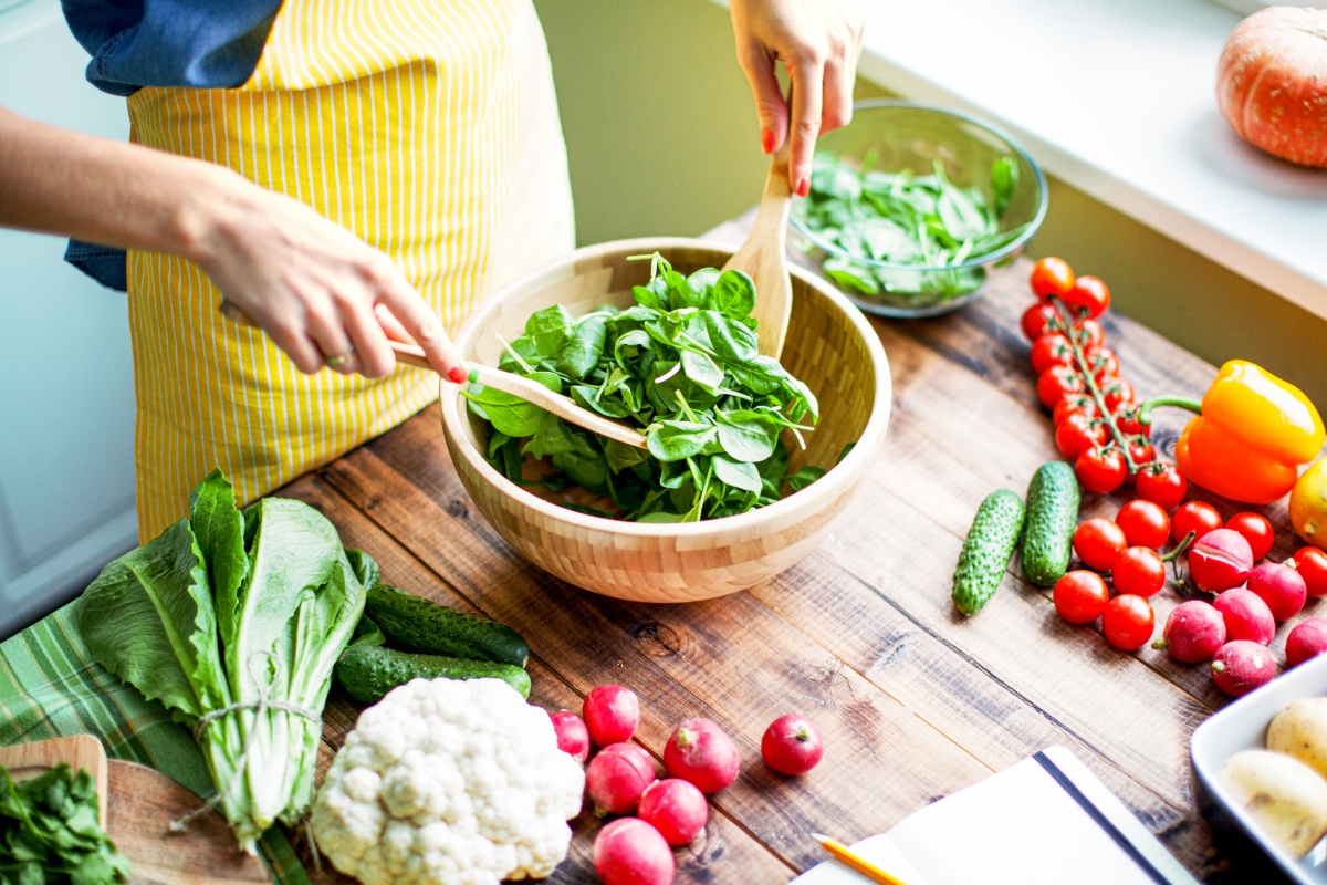 Eine Frau ist gerade dabei einen Salat zuzubereiten.