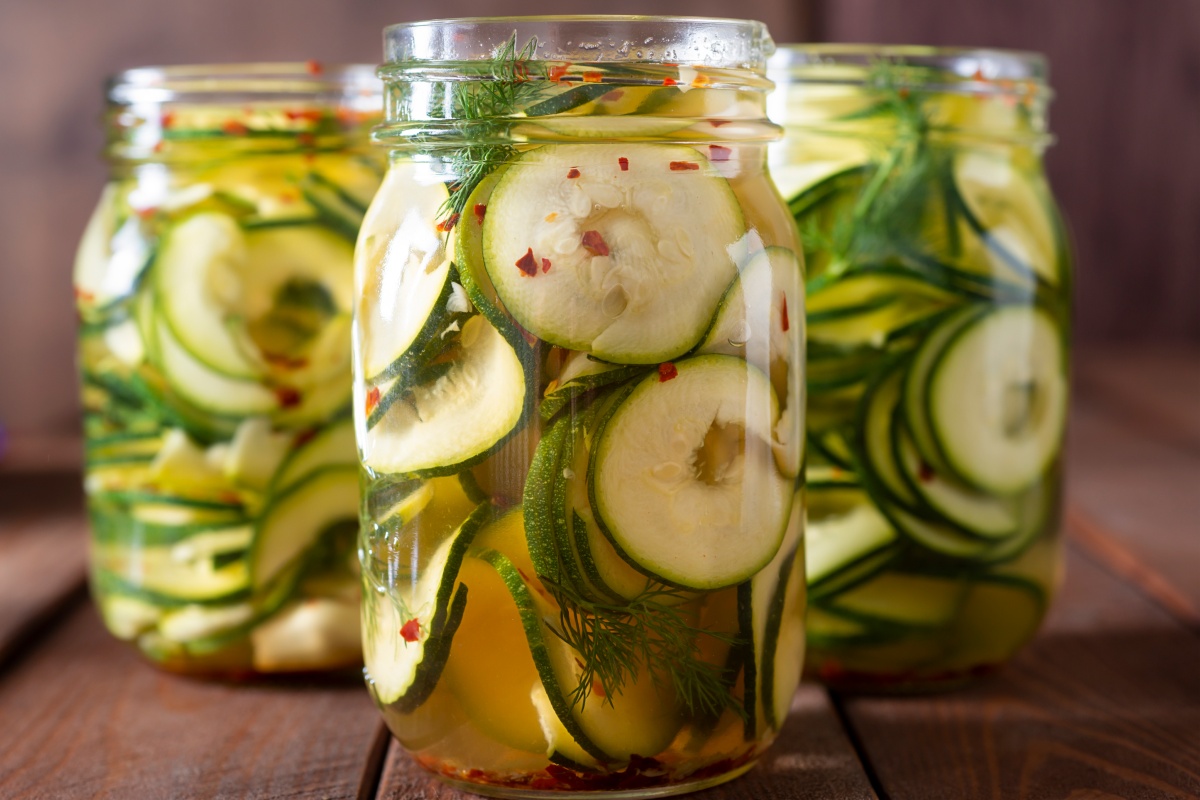 Eingemachte Zucchinischeiben mit Gewürzen und Dill in Gläsern.